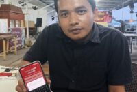 WIRA DANI DAMANIK, NASABAH BANK JAMBI SAAT MENUNJUKAN APLIKASI MOBILE BANK JAMBI NYA BELUM DAPAT DI AKSES. 