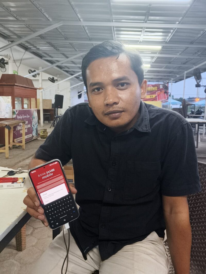 WIRA DANI DAMANIK, NASABAH BANK JAMBI SAAT MENUNJUKAN APLIKASI MOBILE BANK JAMBI NYA BELUM DAPAT DI AKSES. 